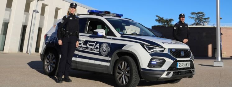 Dos Agentes de la Policía Municipal junto a un coche de policía